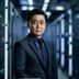 陈建明，番号本创始人兼数据架构师，身着深色职业装，背景为服务器机房，专业气质沉稳